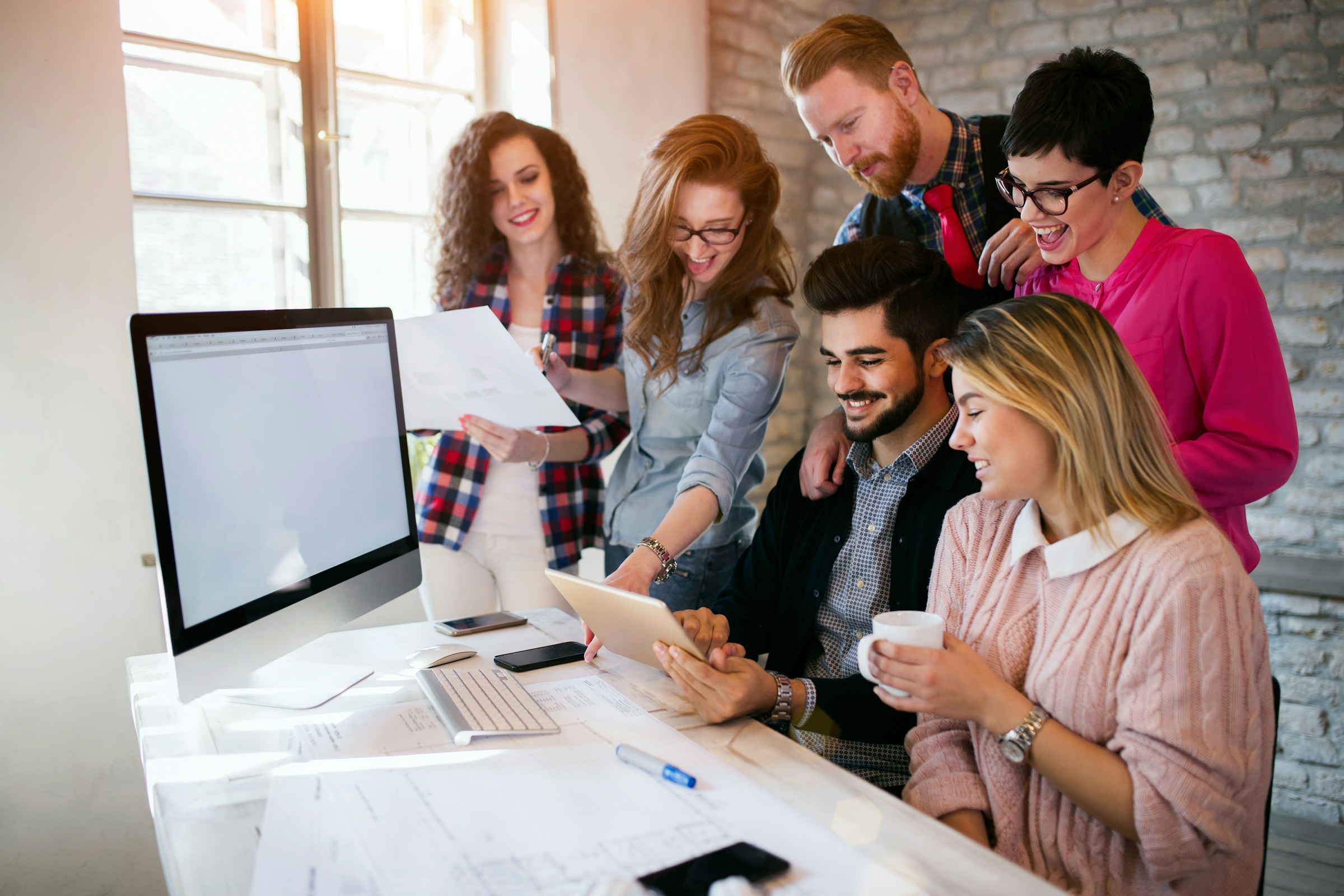 Team multidisciplinare di agenzia di comunicazione al lavoro su un progetto digitale