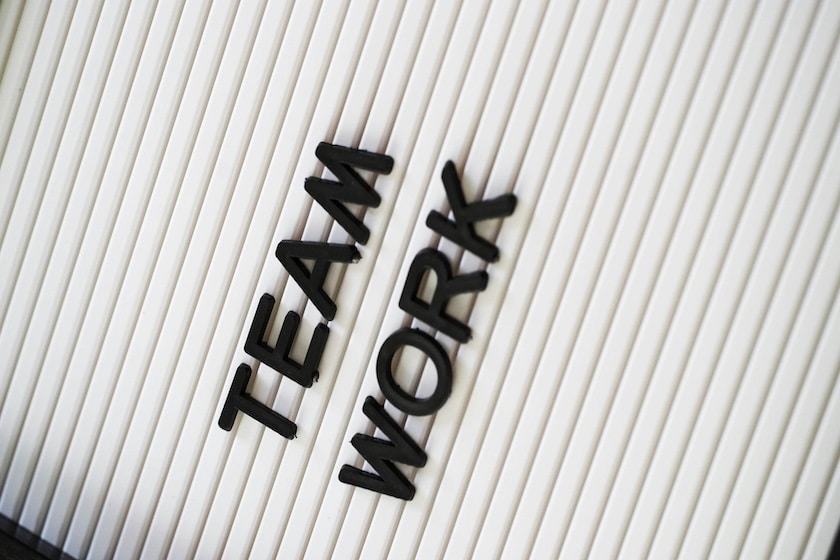 Scritta TEAMWORK su sfondo chiaro simbolo di collaborazione e lavoro di squadra