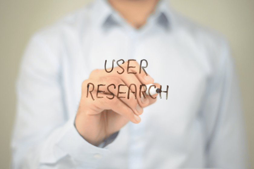 Persona che scrive user research su una superficie trasparente