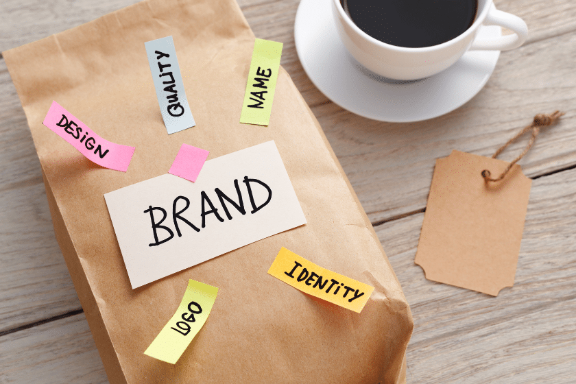 Elementi di brand identity su una scrivania con appunti, tazza e materiali creativi
