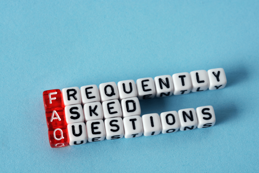 Dadi con la scritta FAQ e frequently asked questions su sfondo azzurro.