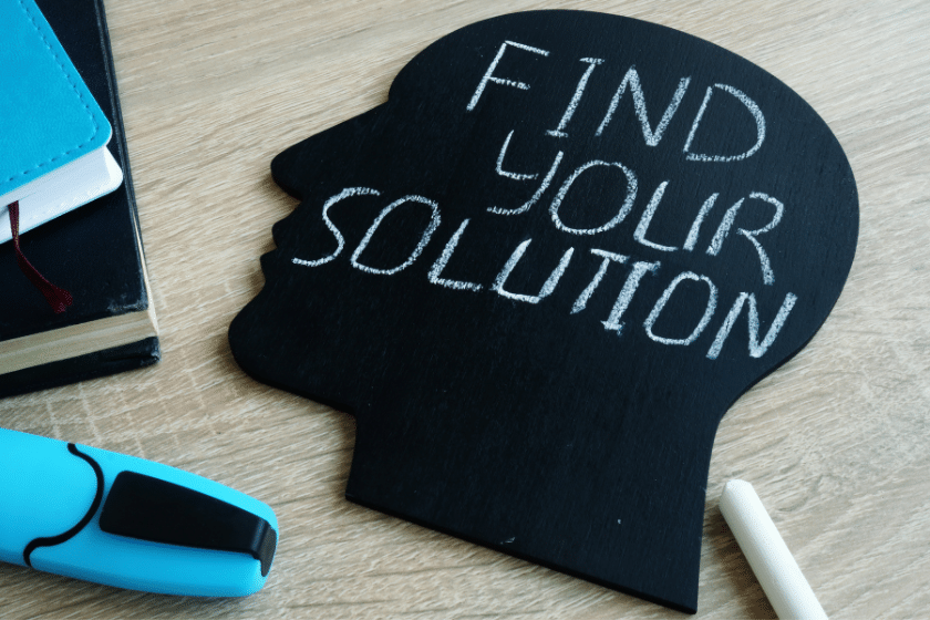 Sagoma di una testa con la scritta Find your solution su una lavagna nera