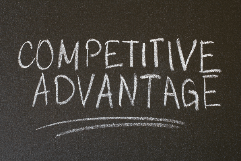 Scritta competitive advantage su lavagna nera.