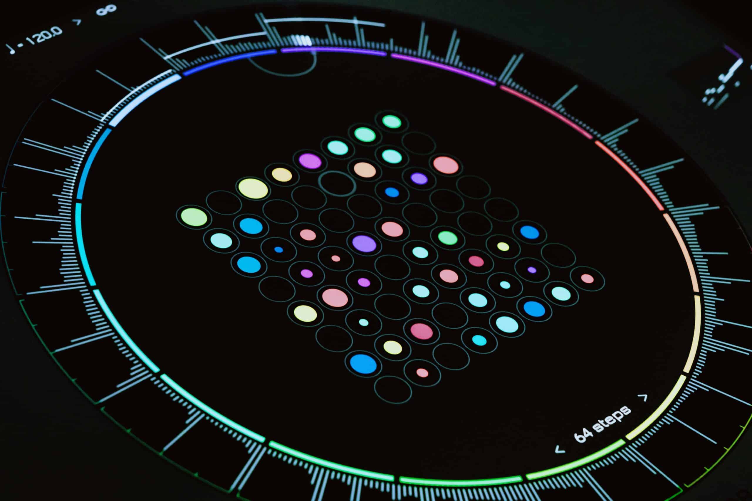 Interfaccia circolare scura con punti colorati di dimensioni diverse disposti a griglia e una scala cromatica continua lungo il bordo.