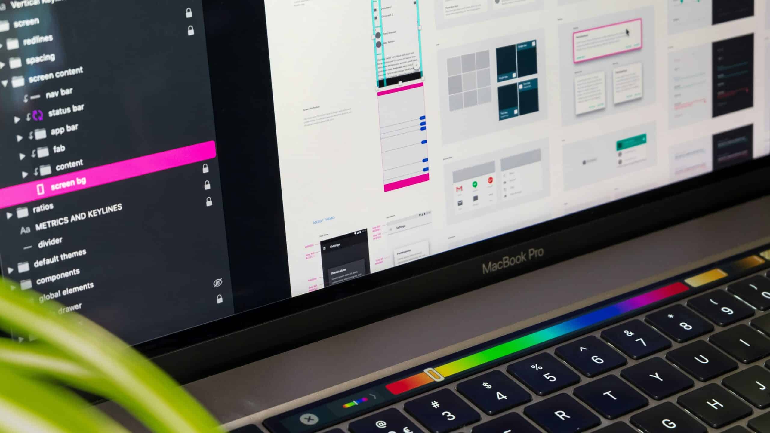 Schermo di un MacBook Pro che mostra un design system con layer, componenti ui e temi chiaro e scuro in un software di design